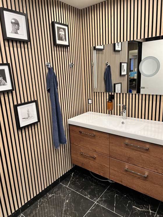 Badezimmer mit Waschtisch, Spiegel und Holzlamellen