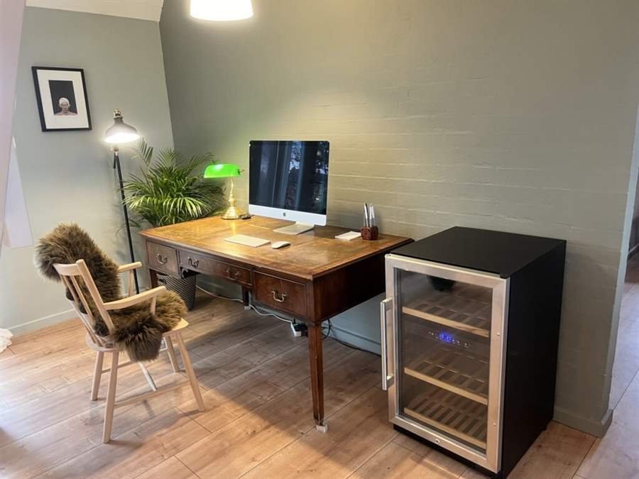 Arbeitsplatz mit Schreibtisch und Weinkühlschrank